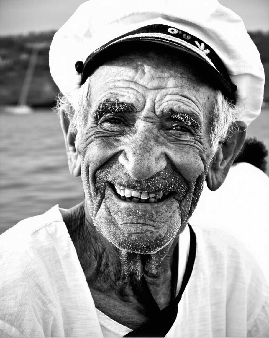 black and white portrait of an old but happy french sailor, 50mm photography, canon eos
