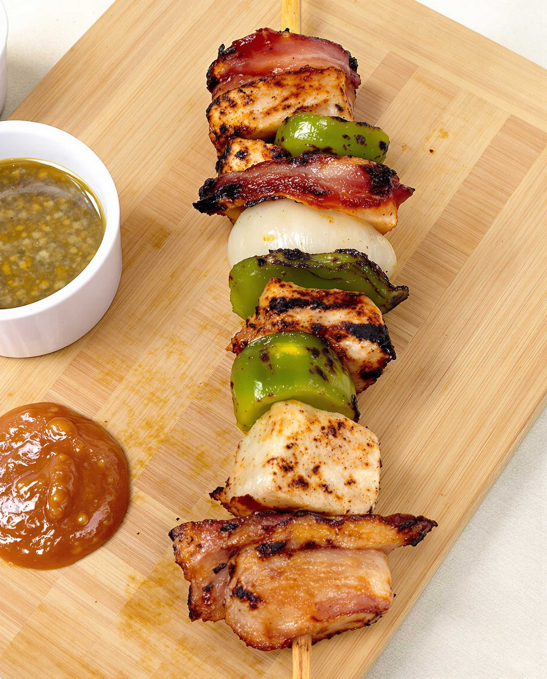 Skewered Meat Kebab with Dipping Sauce on Wooden Cutting Board