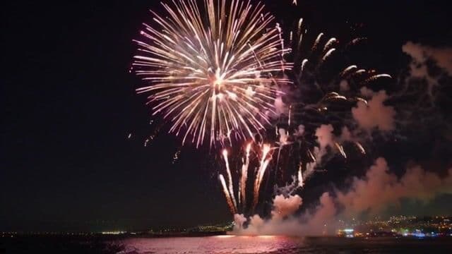 Amazing massive Firework over ocean side city skyline. 
