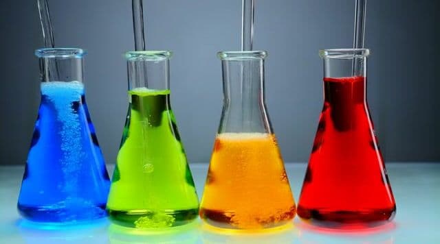 a set of 6 colorful beakers bubbling in a lab