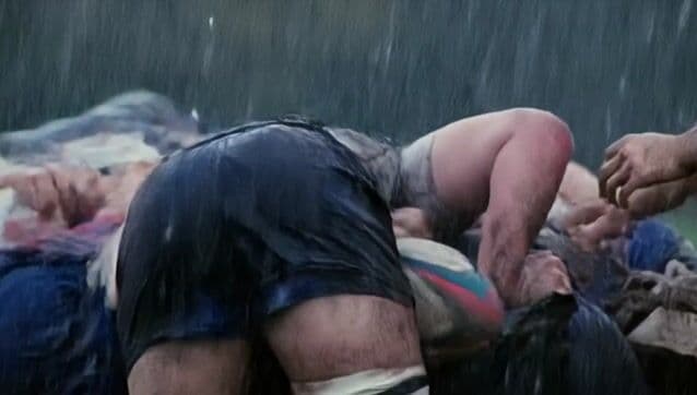 Intense tracking shot navigates rugby scrum, mud and rain flying