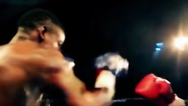 Frantic camera weaves between boxers trading punches, lights flaring
