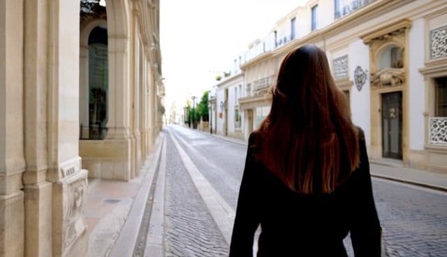 a stylish woman walks down the streets of lisbon