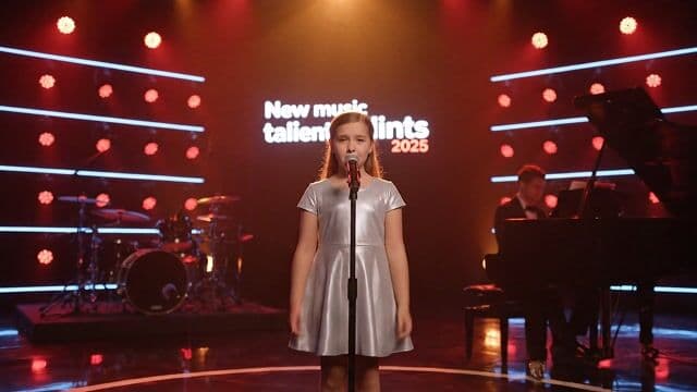 {
  "subject": "a 10-year-old girl performing on stage during a televised music talent show, wearing a shiny silver dress, standing confidently at the center microphone",
  "pose": "singing gently with expressive hand gestures, standing upright and focused, emotionally immersed in the song",
  "environment": "large modern talent show stage bathed in warm red and orange spotlights, accented by subtle blue LED strips in the background; a glowing sign reads 'New music talents 2025' behind the performers",
  "camera": {
    "motion": "starts with a cinematic wide-angle stage overview, then slowly zooms in to a centered close-up on the girl while maintaining shallow depth of field",
    "focus": "sharp on the young singer, blurred background including piano and band",
    "angle": "eye-level with smooth dolly movement",
    "simulation": "ARRI ALEXA Mini LF with 50mm cine prime lens"
  },
  "lighting": {
    "type": "theatrical stage lighting",
    "colors": ["warm red", "deep orange", "cool blue highlights"],
    "intensity": "soft golden front light with rim lighting from behind, subtle lens flares from spotlights",
    "mood": "warm, emotional, and cinematic"
  },
  "mood": "inspirational, tender, powerful stage presence of a young artist",
  "details": {
    "face": "natural, youthful expression with soft makeup and shimmering eye light from spotlights",
    "body": "small silhouette in elegant silver dress, gently lit from all angles",
    "makeup": "minimal with slight gloss to enhance stage presence",
    "hair": "neatly styled, catching the glow of the lights"
  },
  "audio_cues": {
    "vocals": "crystal-clear child voice with delicate vibrato, emotional delivery of 'Sound of Silence'",
    "instrumentals": "grand piano played by a young man beside her, with light but powerful backing from drums and guitars in the background"
  },
  "render_style": "cinematic broadcast-quality stage video with subtle slow-motion accent during emotional peaks, photorealistic lighting and lens simulation",
  "meta_tokens": [
    "stage backlight bloom",
    "cinematic depth of field",
    "warm tone color grade",
    "studio lens flares",
    "ARRI LUT",
    "hyperreal lighting simulation",
    "performance spotlight",
    "slow zoom cinematic"
  ],
  "lens_type": "50mm T1.5 cinema lens with shallow depth of field",
  "image_format": "16:9 full HD broadcast, HDR color grade",
  "file_signature": "TALENTSHOW_2025_EP3_VOX01.ALEXA"
}