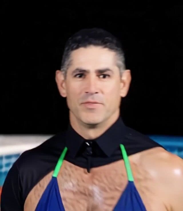 He is swimming in a pool of hot dogs wearing wearing a bikini, the hot dogs are floating everywhere around him 