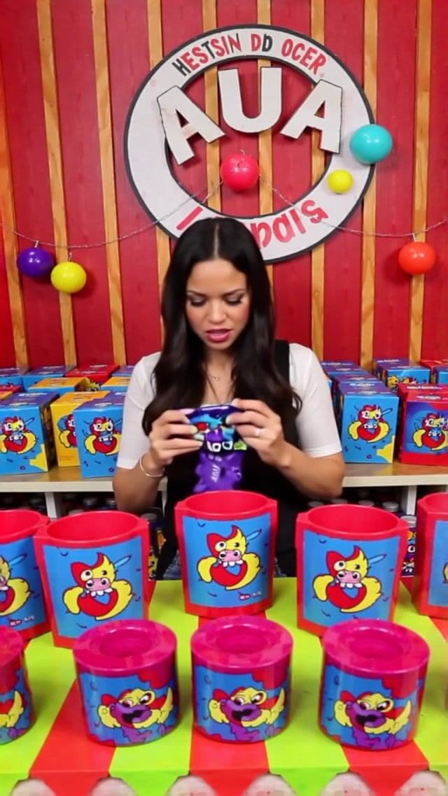 A realistic scene of a woman in a candy store frantically searching to find the last pixel dojo candy bar. once she finds it she exclaims, "gotta have that pixel dojo candy". the candy features a pixelated purple dragon with the text "pixel dojo" on the wrapper.