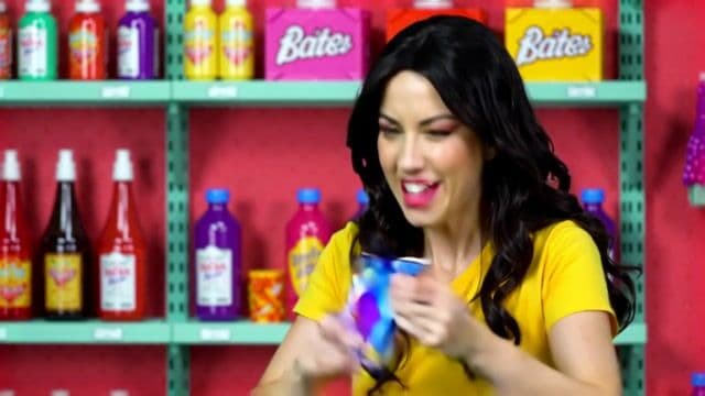 A realistic scene of a woman in a candy store frantically searching to find the last pixel dojo candy bar. once she finds it she exclaims, "gotta have that pixel dojo candy". the candy features a pixelated purple dragon with the text "pixel dojo" on the wrapper.