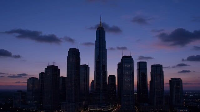 city skyline at dusk, slow camera tilt up, glowing windows and passing clouds