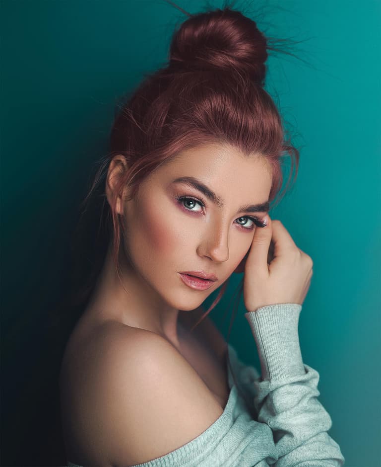 Captivating Portrait of a Woman with a Topknot and a Teal Background