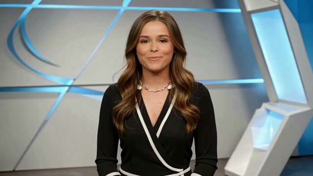 a friendly professional presenter speaking to camera in a bright modern studio, natural hand gestures, broadcast quality