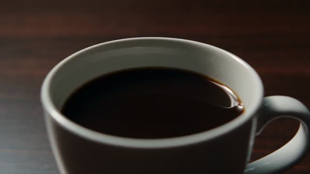 [0-5s]: Cinematic shot in a dark room. Slow-motion camera zooming in on a cup of coffee. The coffee inside transforms into a glowing cobalt blue #1952F0 liquid, forming the shape of @Image1.

[05-10s]: Suddenly, a fierce 3-headed hydra dragon made of blue liquid erupts from the cup, wearing the glowing @Image1 logo emblem on its chest, roaring aggressively as blue sparks fly everywhere.

[10-15s]: A man in the scene recoils in shock, knocking over his chair. The hydra dragon shoots a intense wave of cobalt blue #1952F0 fire upward, hyper-realistic physics, cinematic lighting.