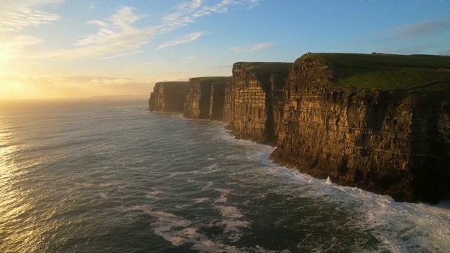 cinematic aerial drone shot, coastal cliffs at golden hour, slow forward dolly, photorealistic, ARRI Alexa look