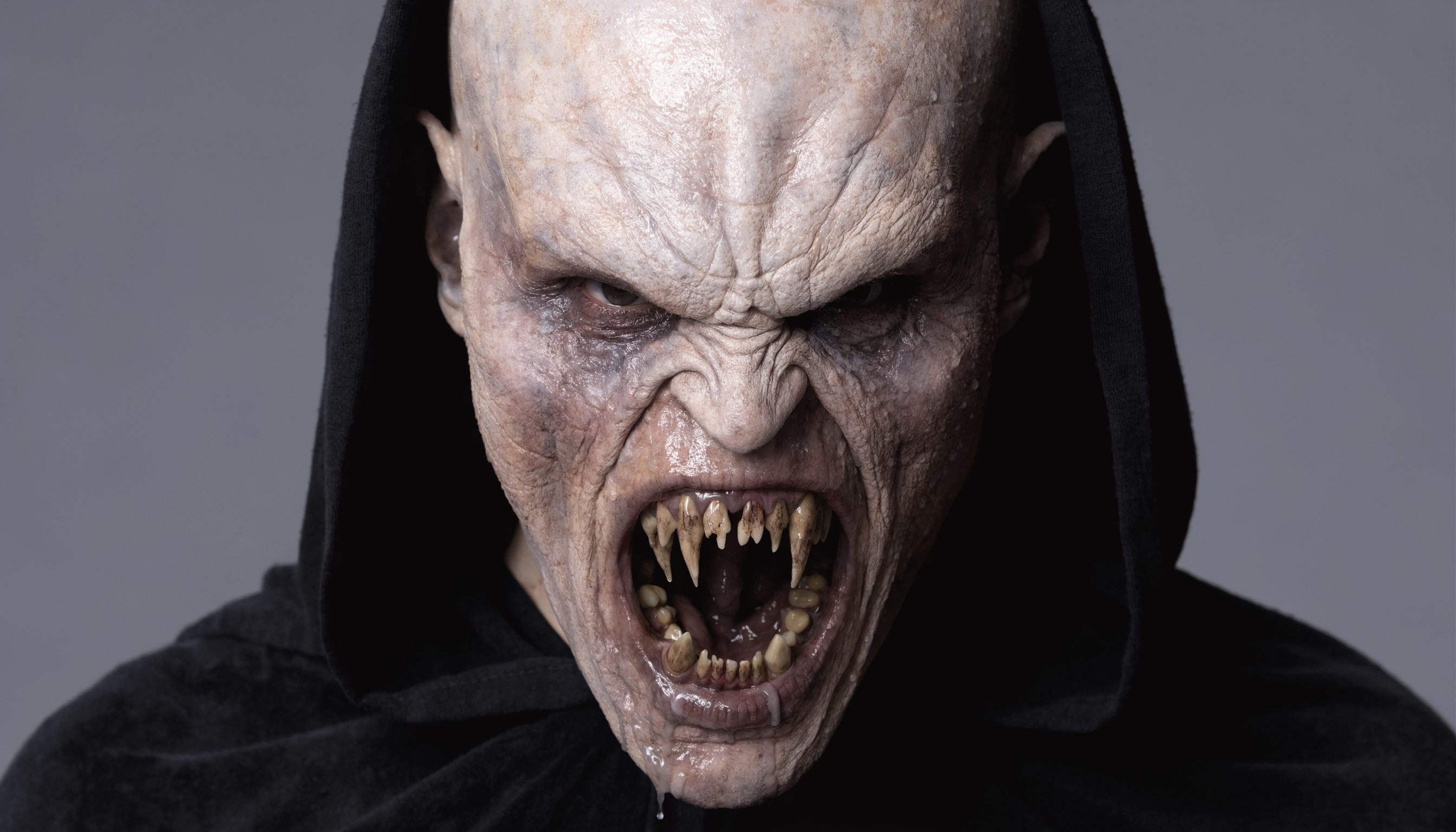 hyper-realistic close-up portrait of a menacing bald alien humanoid creature with pale, fleshy, wrinkled skin in a grotesque Hollywood special effects makeup style, highly detailed textures showing deep vertical ridges across the high forehead and cranium, sagging skin folds around the cheeks and jawline, piercing narrow eyes sunken into bony sockets with intense furrowed brows conveying rage, wide-open snarling mouth revealing multiple jagged yellowed fangs and sharp incisors dripping with saliva, black hooded robe framing the face with soft fabric folds draping over the shoulders, dramatic cinematic lighting with subtle shadows accentuating every wrinkle and ridge, neutral gray studio background, photorealistic practical effects quality like creature designs from films by Stan Winston or Rick Baker, ultra-high resolution, intricate skin pores, subsurface scattering on flesh tones ranging from sickly beige to bruised grayish-purple, sharp focus on face, professional photography, no text or watermarks