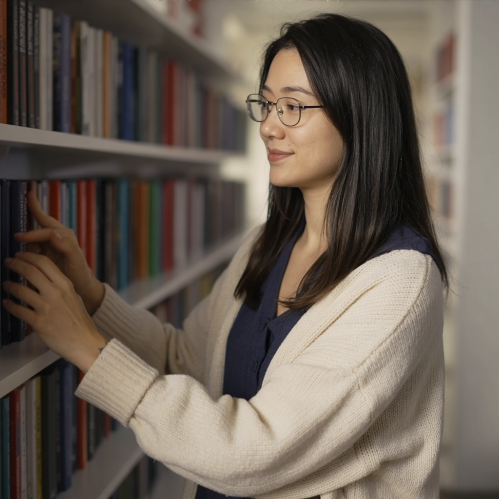 the same person browsing shelves in a cozy bookstore, cardigan, soft lighting