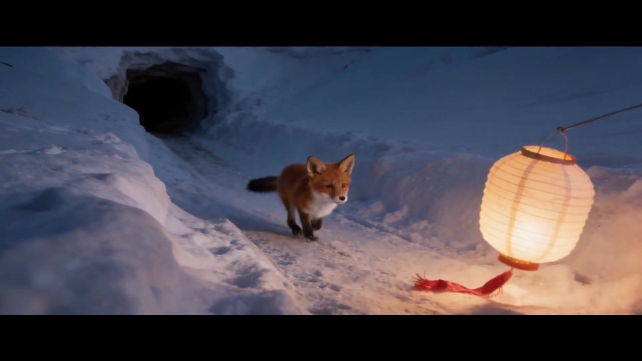 A fox cub follows a glowing paper lantern across the snow at dusk, a shot from Downwind, the film made in the walkthrough.