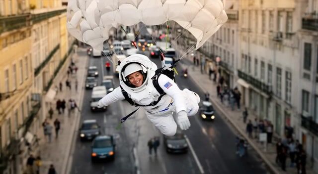 AI-generated image: The camera pans downward as Pamela ejects and descends via parachute, landing with a thud on the str