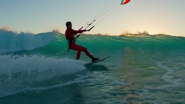 Kitesurfer Arcs Above Turquoise Wave