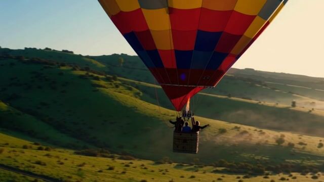 Vibrant Balloon Over Rolling Hills