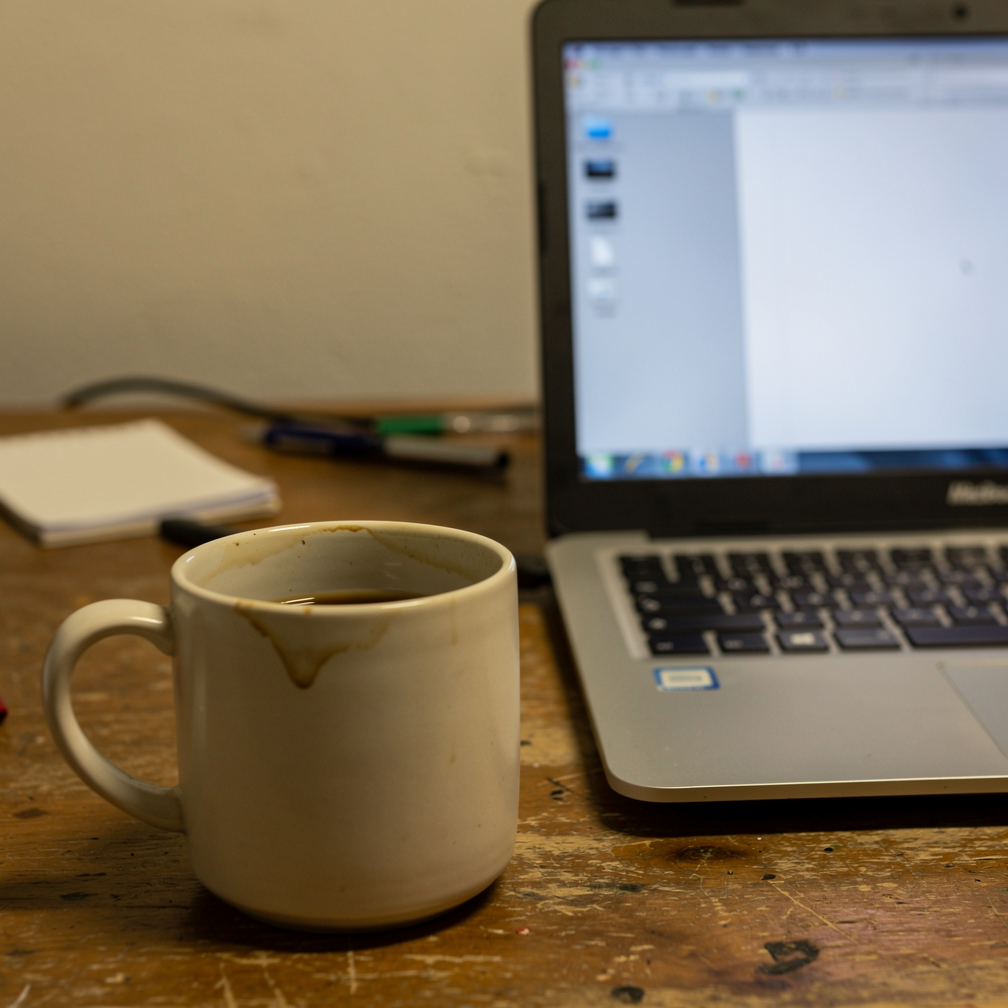 Uploaded reference: casual snapshot of a coffee mug beside a laptop