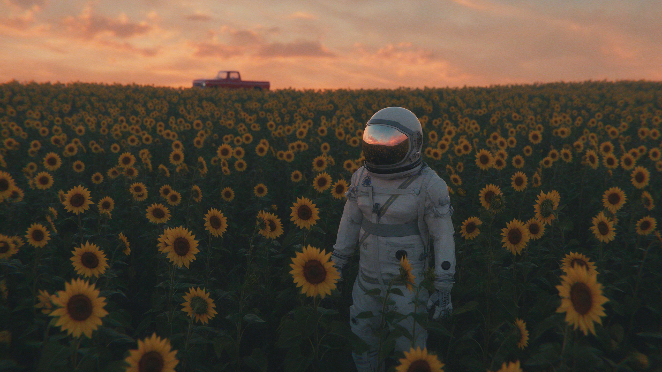 An astronaut stands alone in a sunflower field at dusk, a red truck far behind