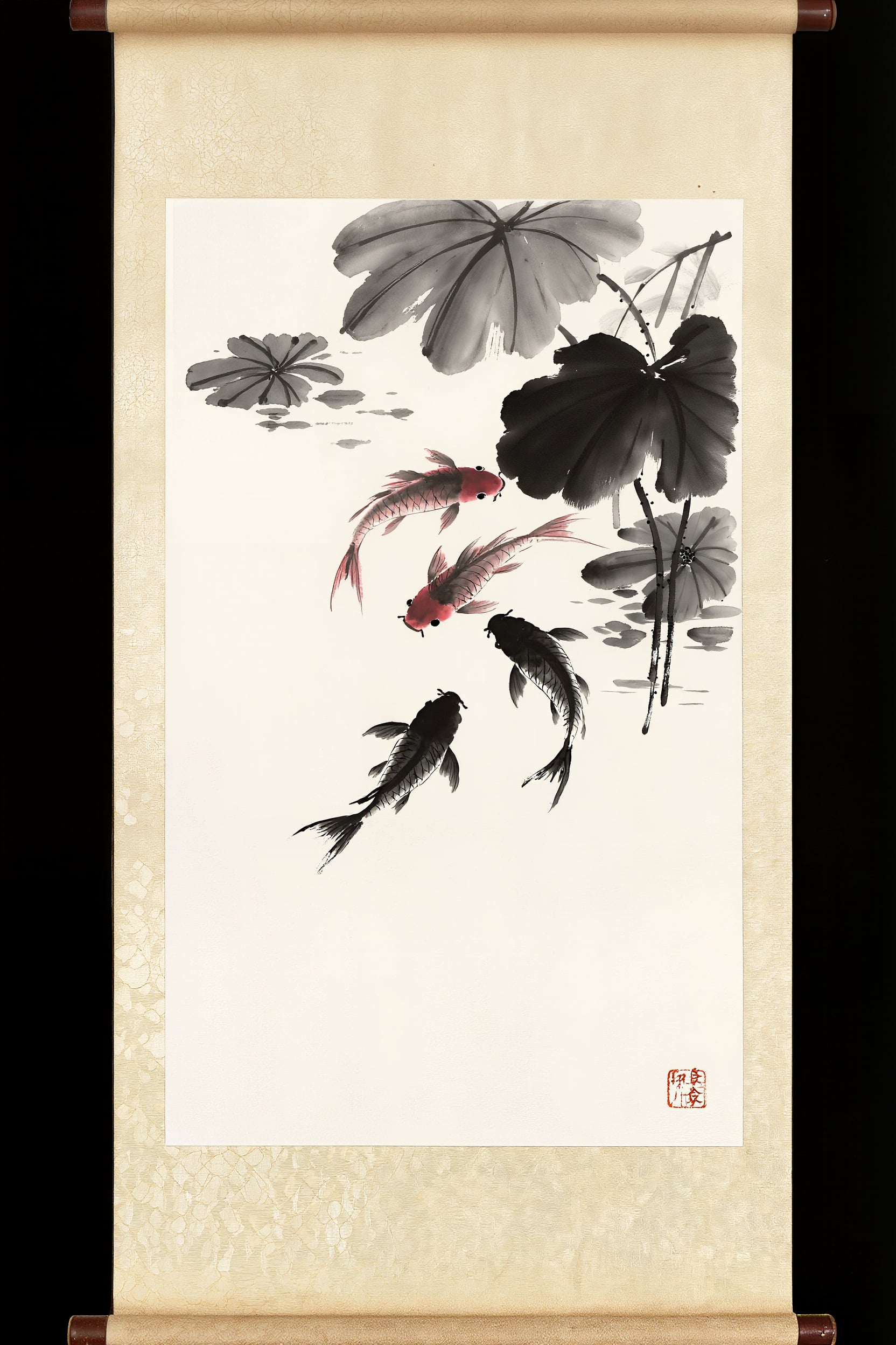 An ink wash painting on a hanging scroll of three koi under lily pads with a red seal stamp