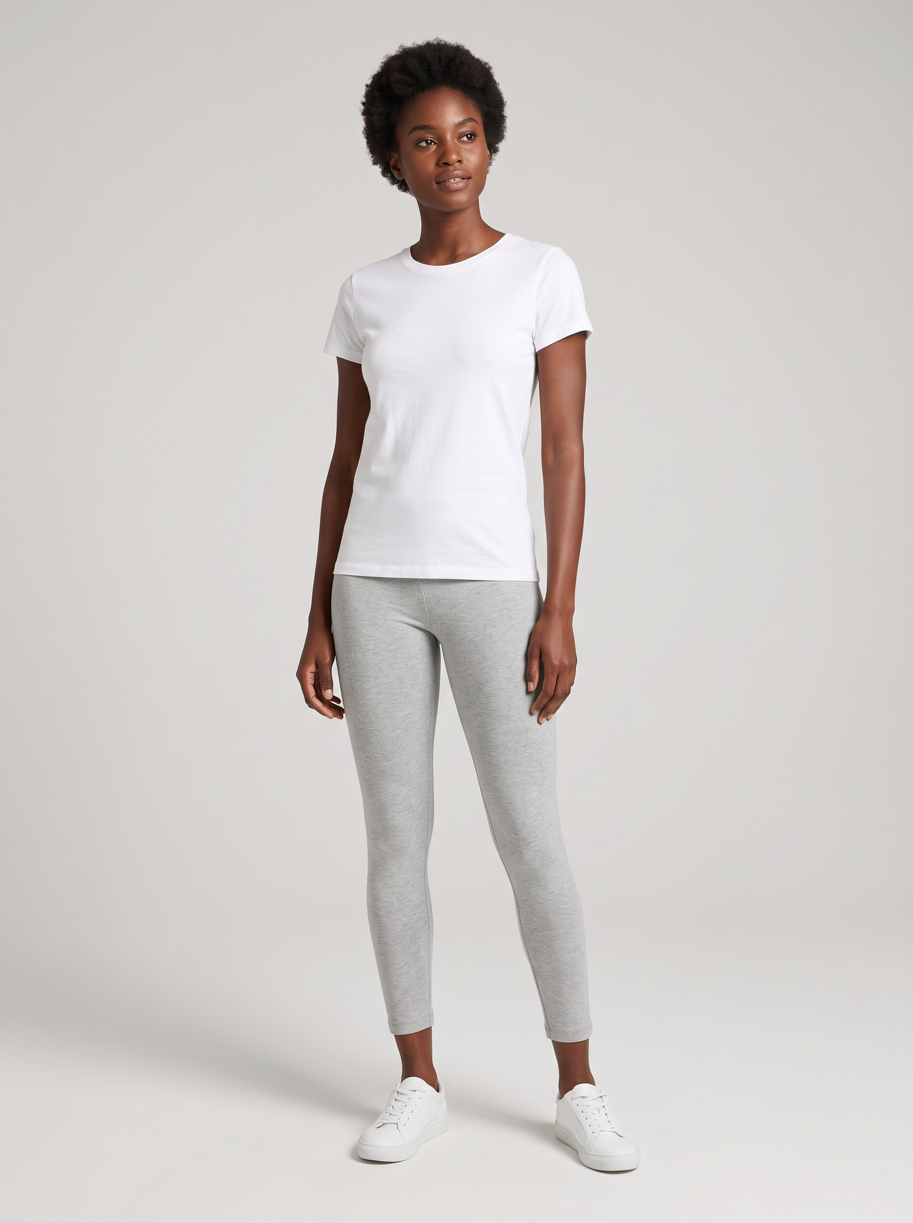 The base photo: a model with short natural curls in a white t-shirt, grey leggings and white sneakers on a grey backdrop