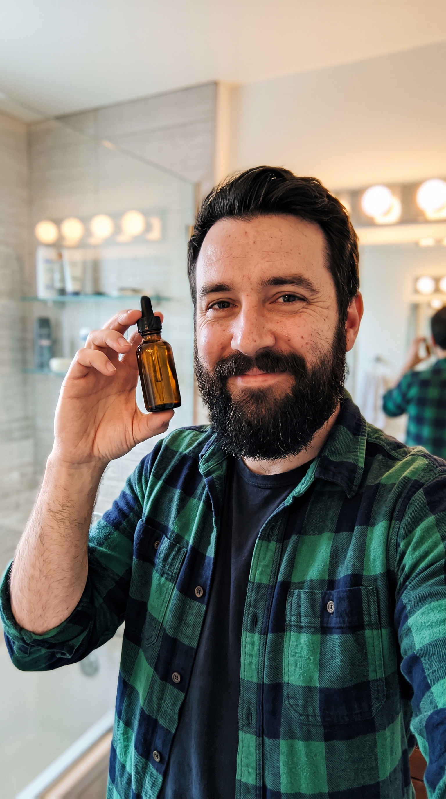 The still: a bearded man in a green flannel shirt holds an amber dropper bottle by his face in a bright bathroom