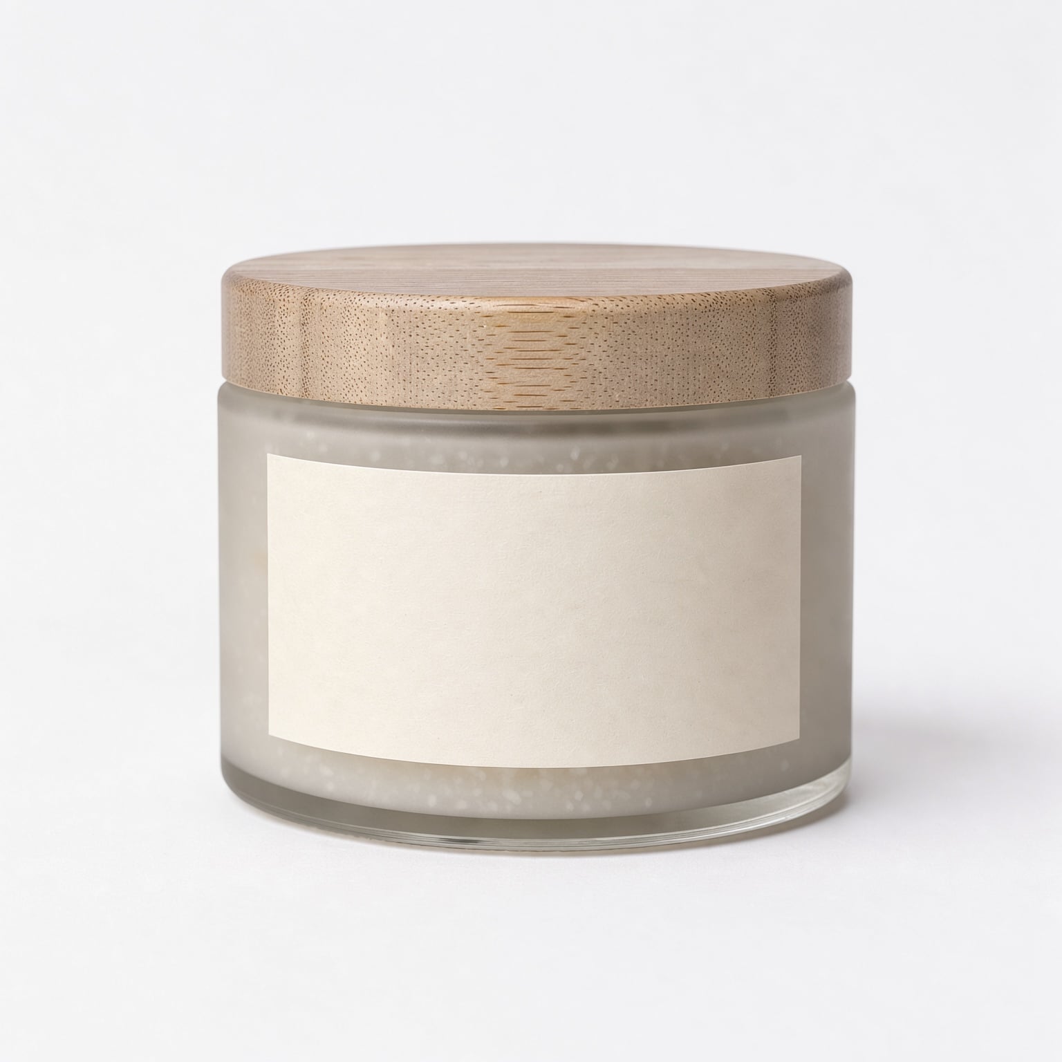 The source packshot: a frosted glass jar with a pale wooden lid and a blank cream label on white