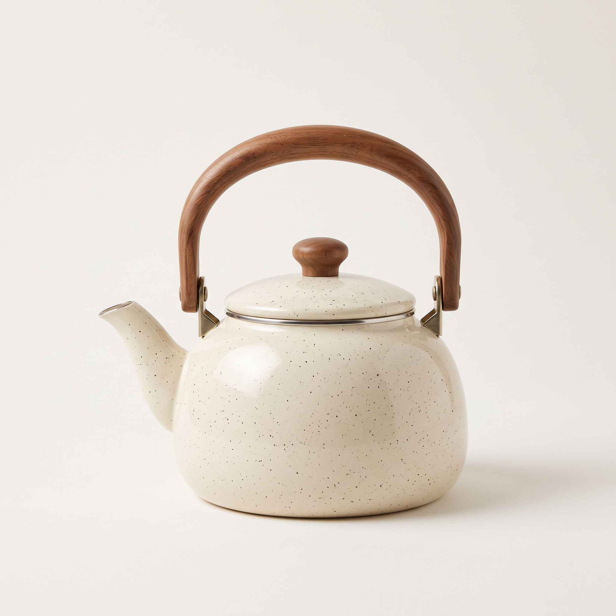 The source: a speckled cream enamel kettle with a walnut handle on a plain warm white background