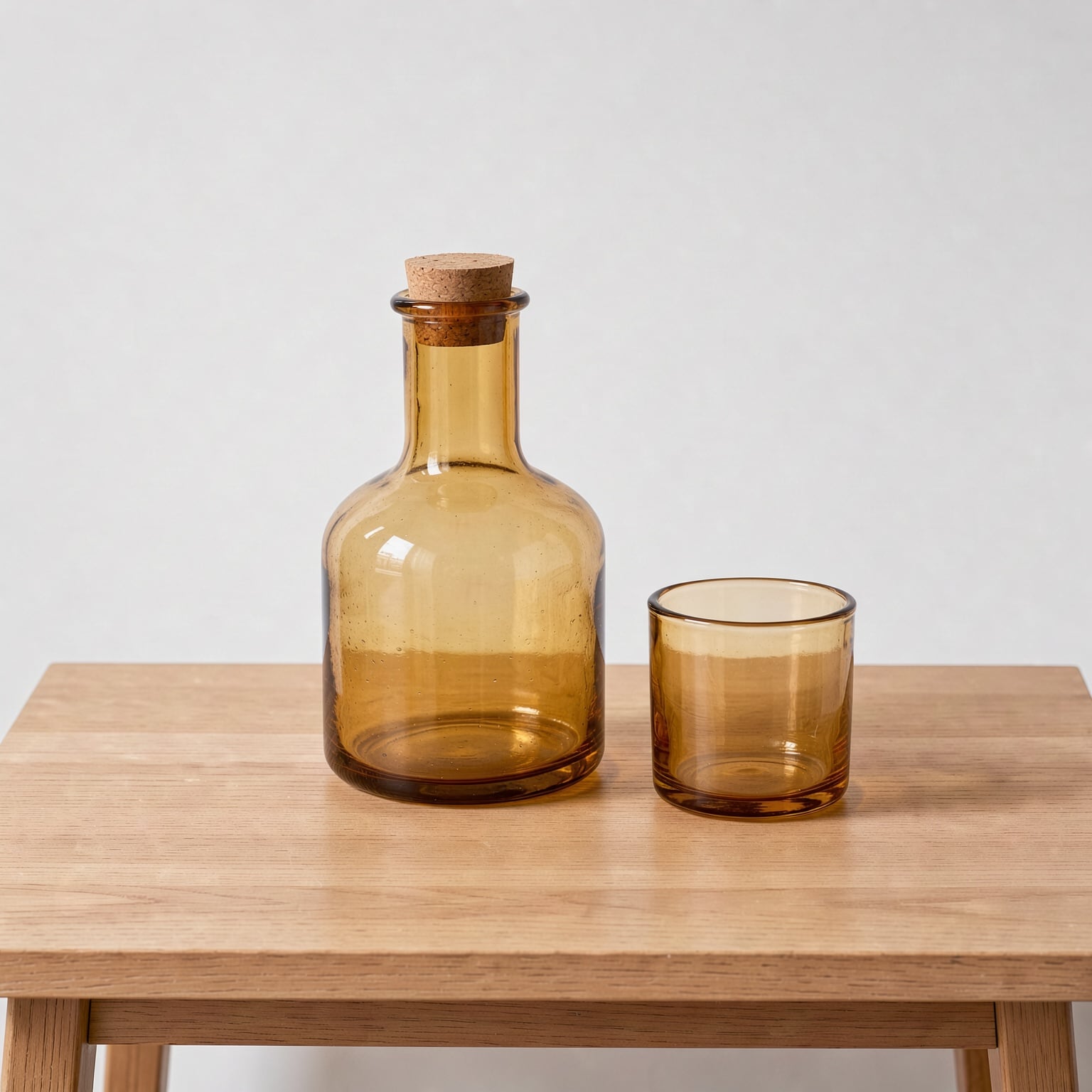 Step 1, FLUX 3 Image: an amber glass carafe with a cork stopper and a tumbler on a pale oak side table in flat daylight